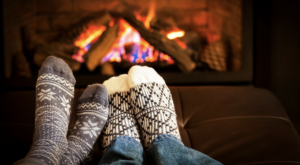 Couple with winter socks cuddled in front of fire place.